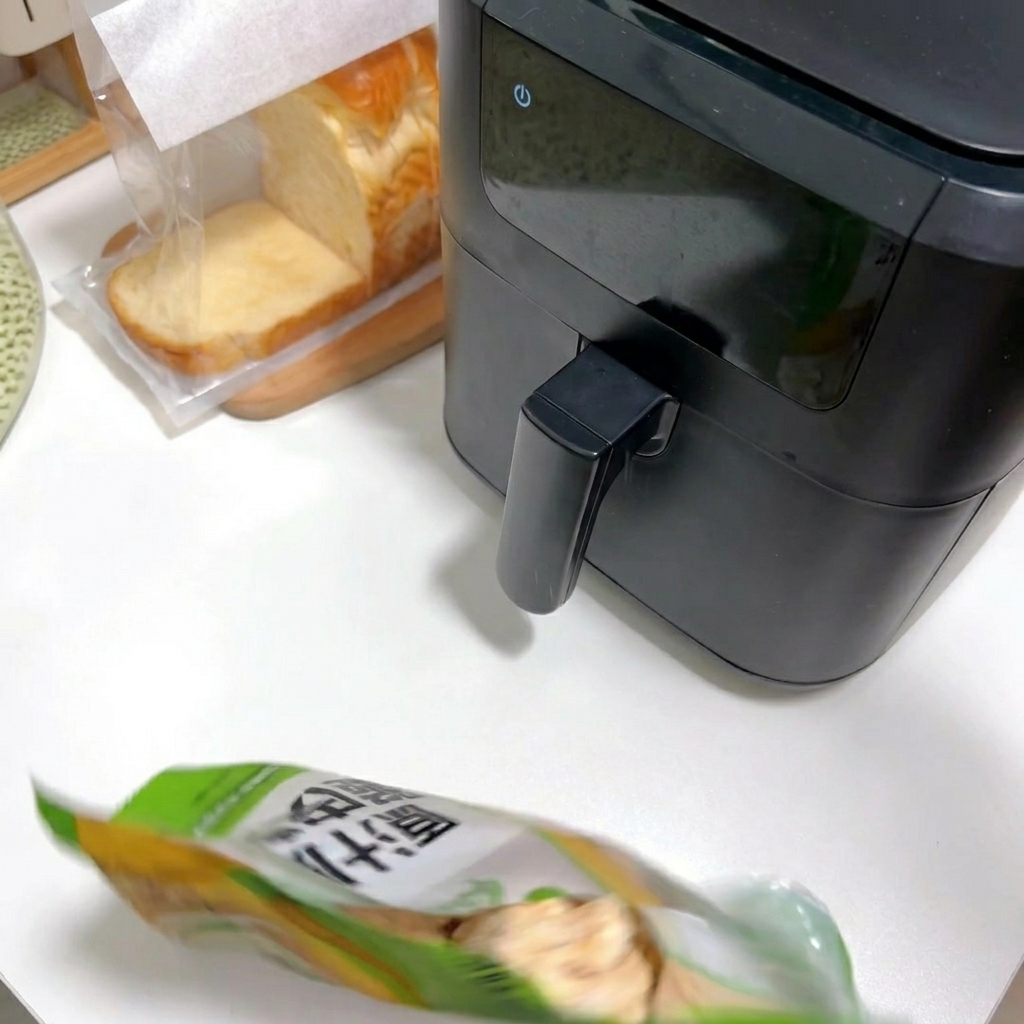 A person opening a package of frozen breaded chicken on a white countertop next to an air fryer.
