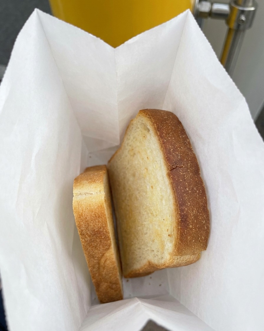 Two thick slices of white sandwich bread resting inside a paper lined plastic bag.