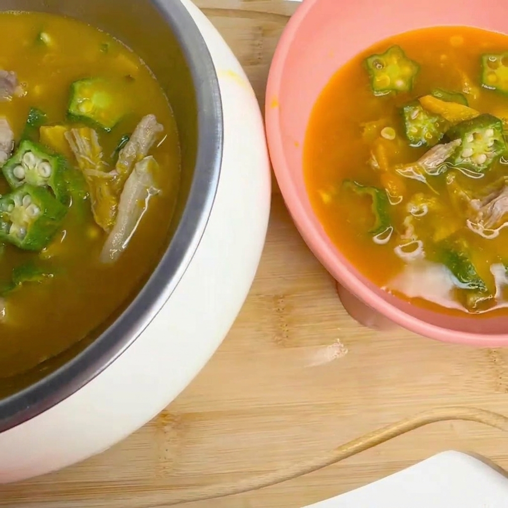 A ladle gently stirring a simmering soup containing okra and duck pieces in a pot.