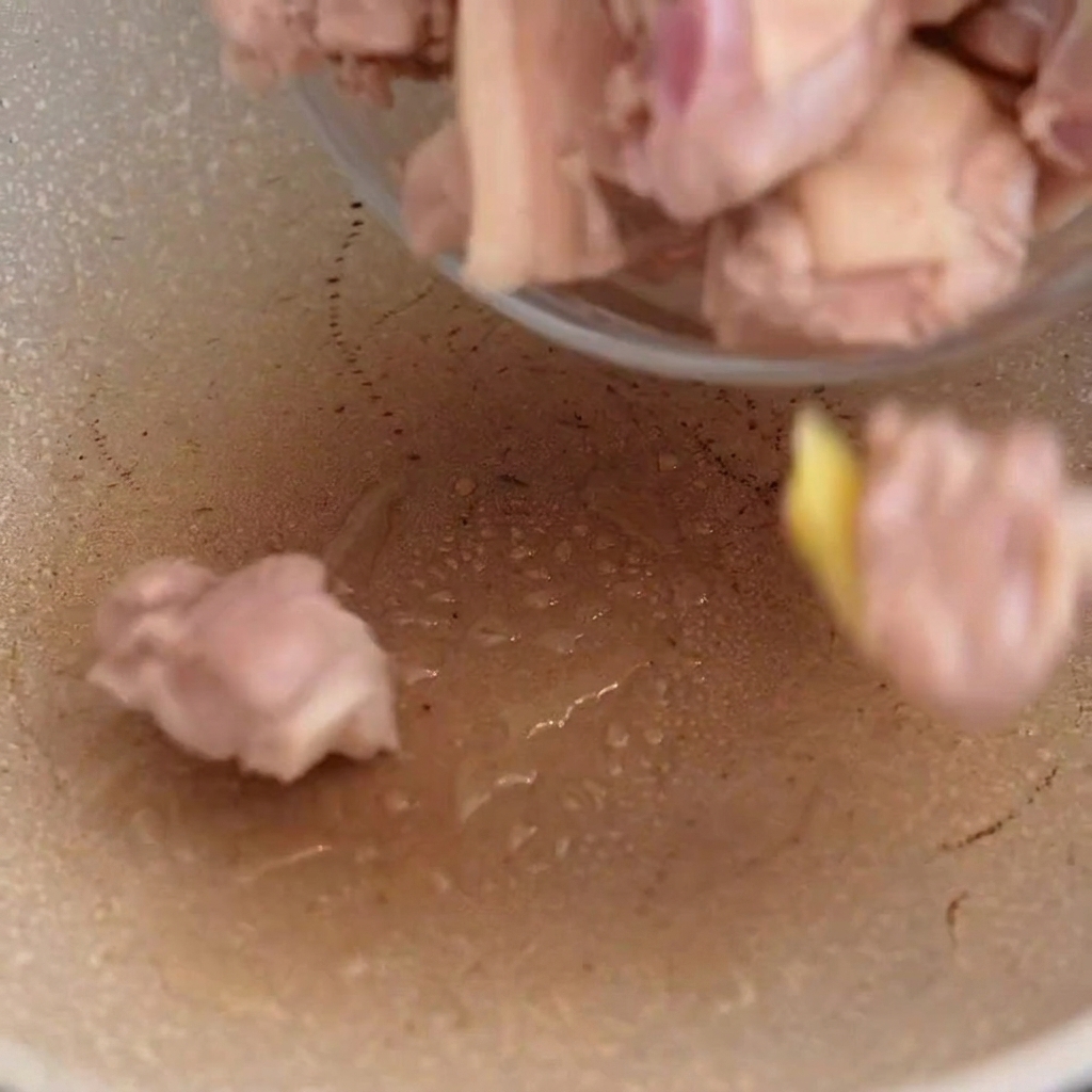 Duck meat being stir fried in a hot pan.