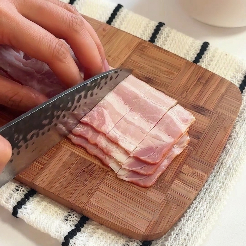 A hand pouring salt and olive oil into a pot of rapidly boiling water.