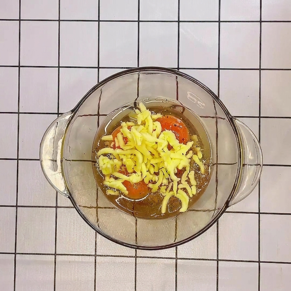 A close-up view of the eggs and cheese being whisked together in a glass bowl.