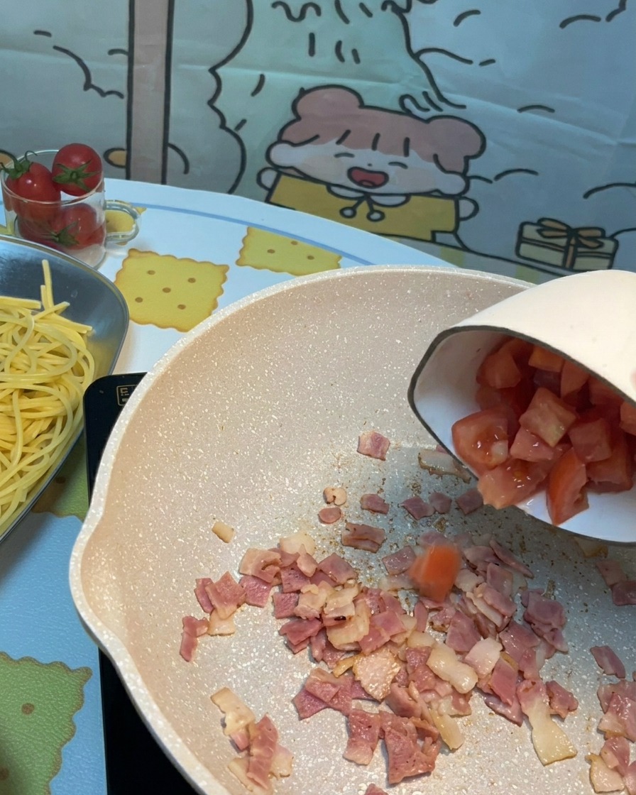 Chopped fresh tomatoes added to the pan with crispy bacon pieces.