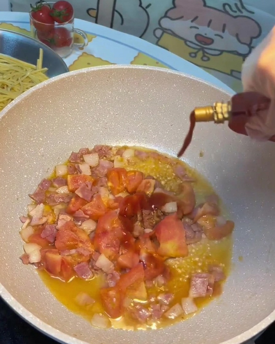 Soy sauce, tomato sauce, and sugar being poured into the pan with bacon and tomatoes.