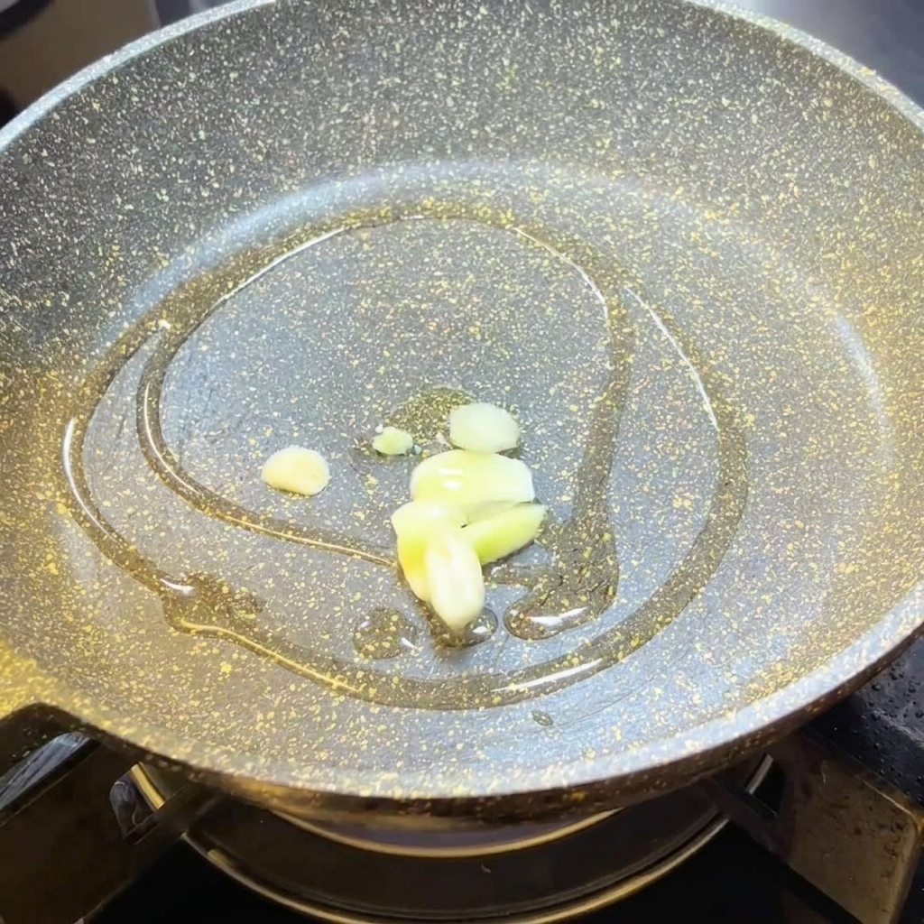 Slices of garlic frying in hot olive oil in a pan.