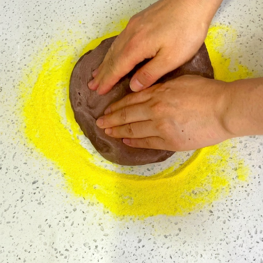 Cherry tomato halves being arranged on top of the pizza base.