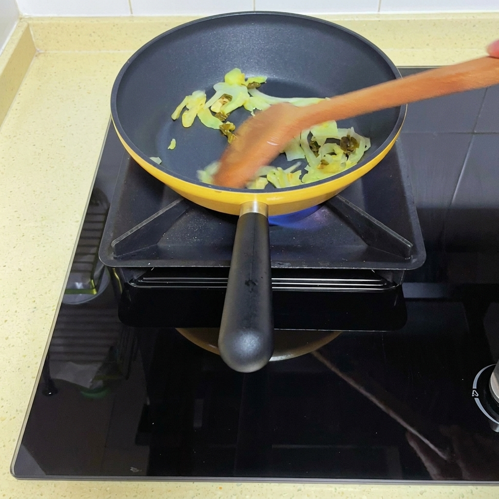 Freshly diced tomatoes being added to the sautéed mustard greens in the pan.
