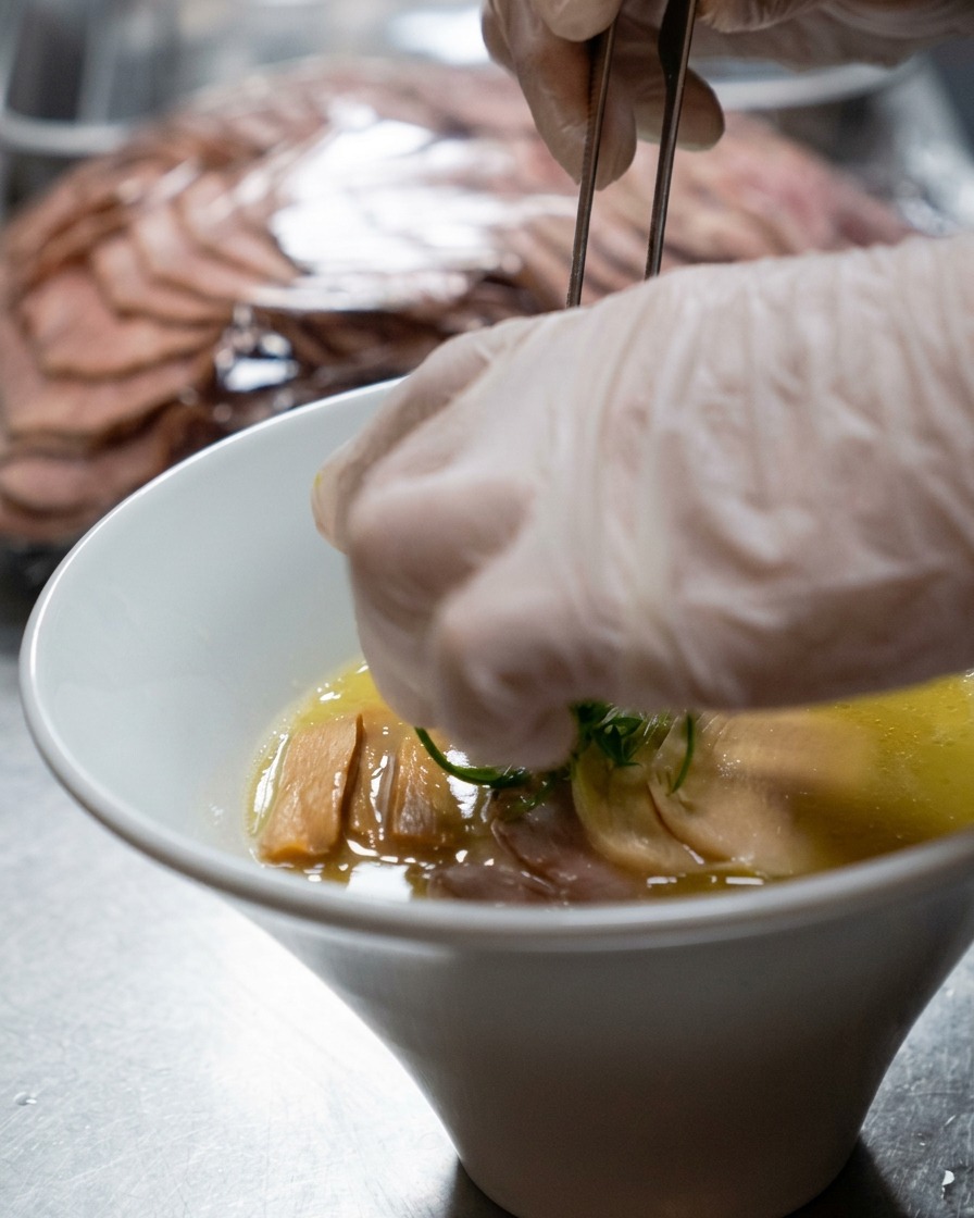 Water and milk being poured together into a metal cooking pot.