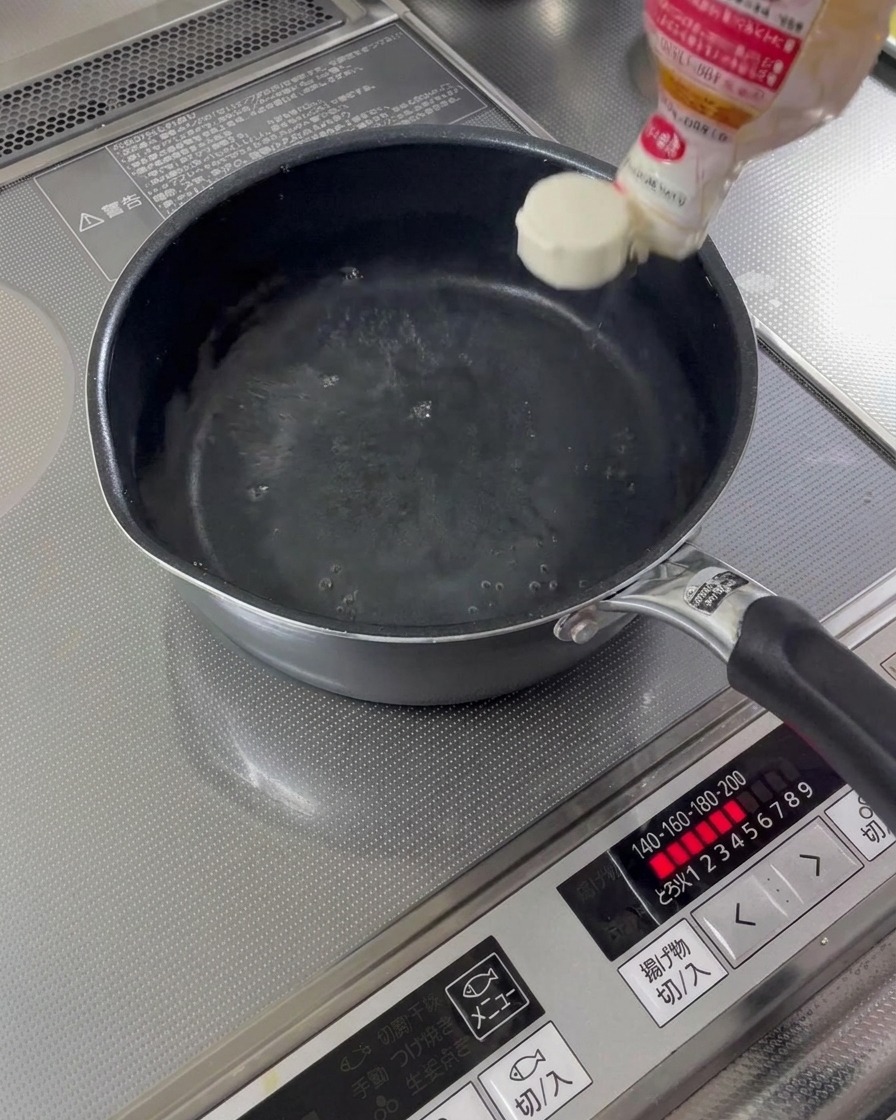 Cooking sake and mirin being poured into a saucepan with water.