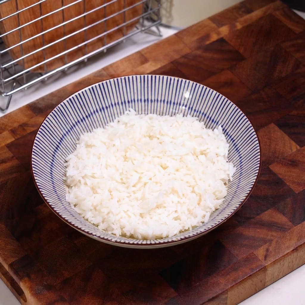 A bowl of plain white rice ready to be topped with the cooked beef mixture.