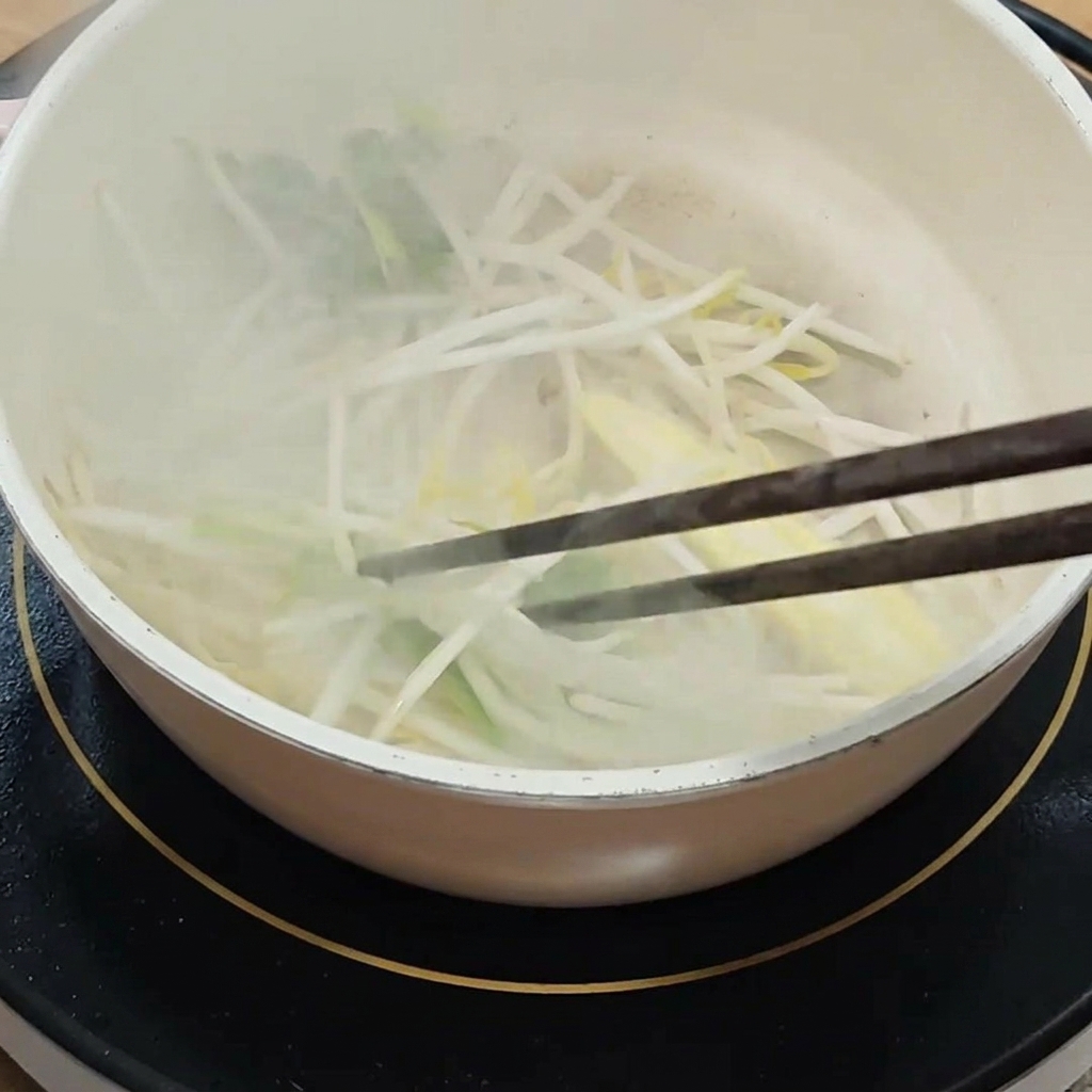 A mixture of dark soy sauce and liquid seasonings being blended in a small white bowl.