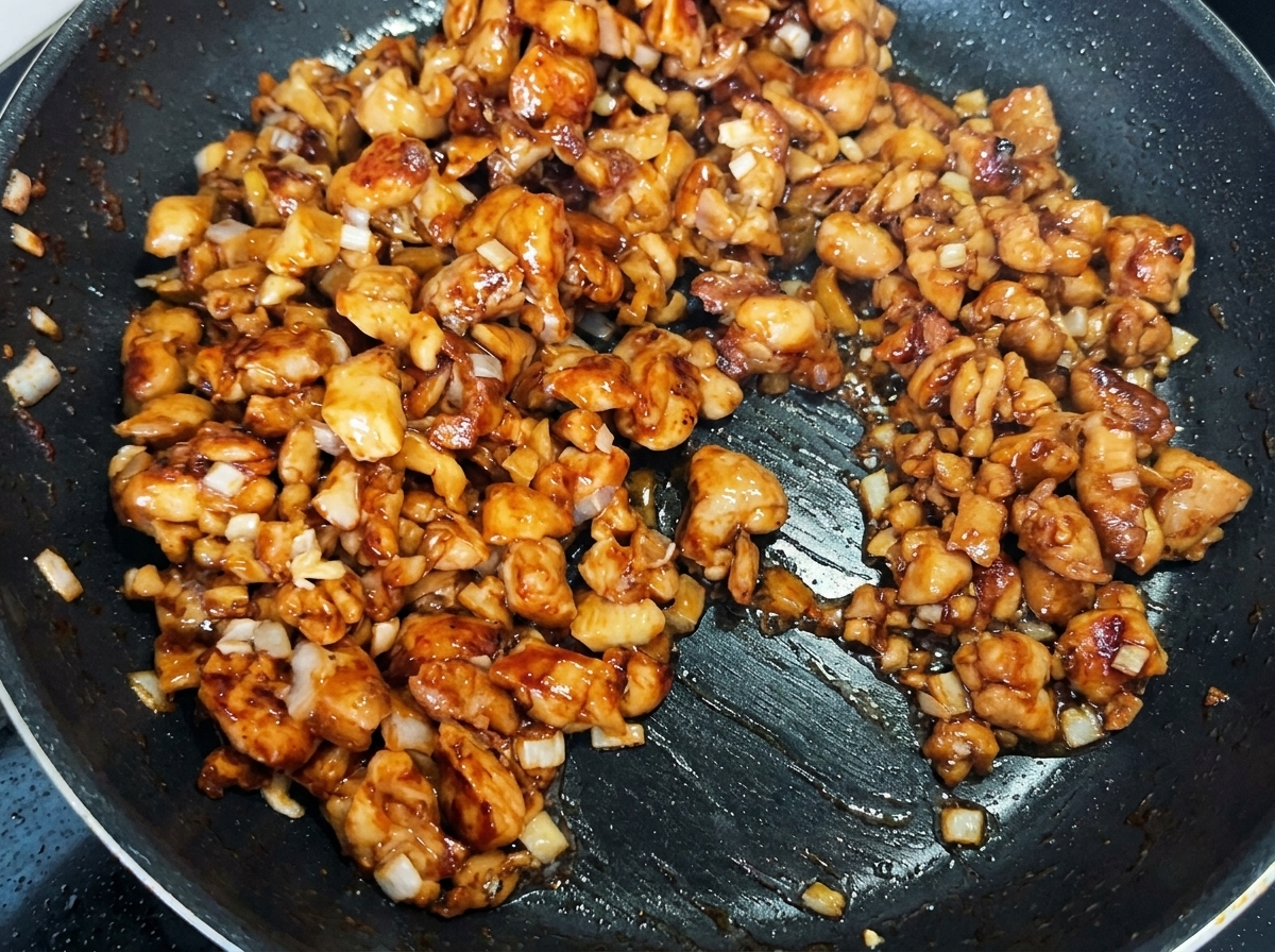 Diced pickled mustard greens mixed with the chicken and scallions in the frying pan.