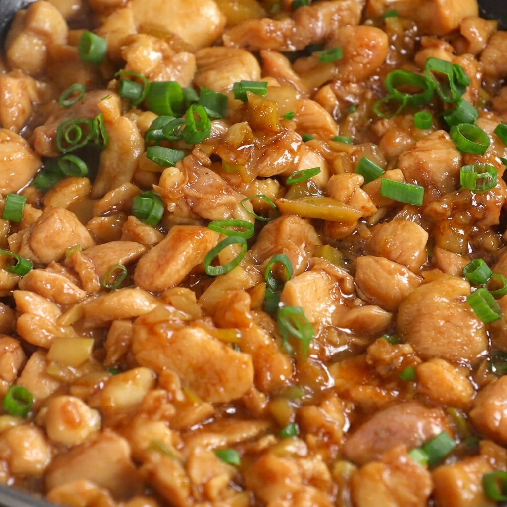 Finished chicken and pickle stir-fry garnished with freshly chopped green onions in a pan.