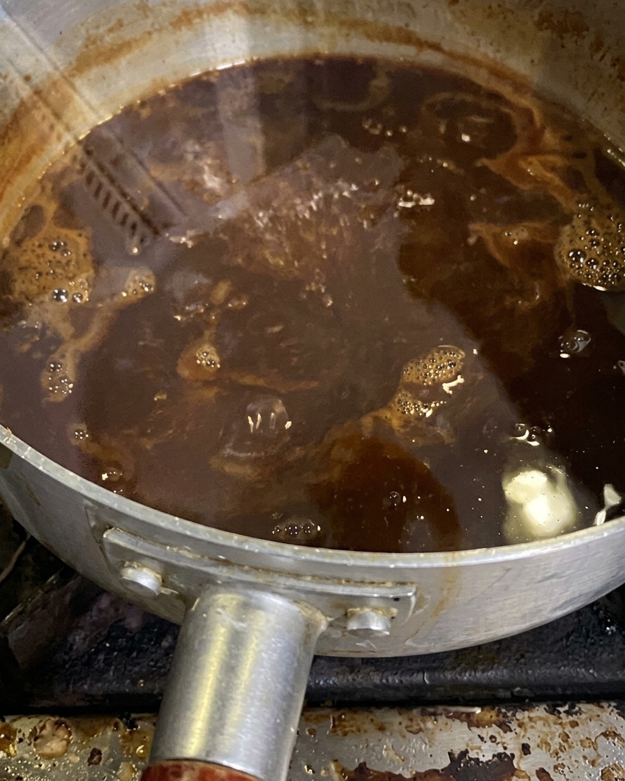 The miso sauce bubbling gently in a saucepan as it simmers and reduces.
