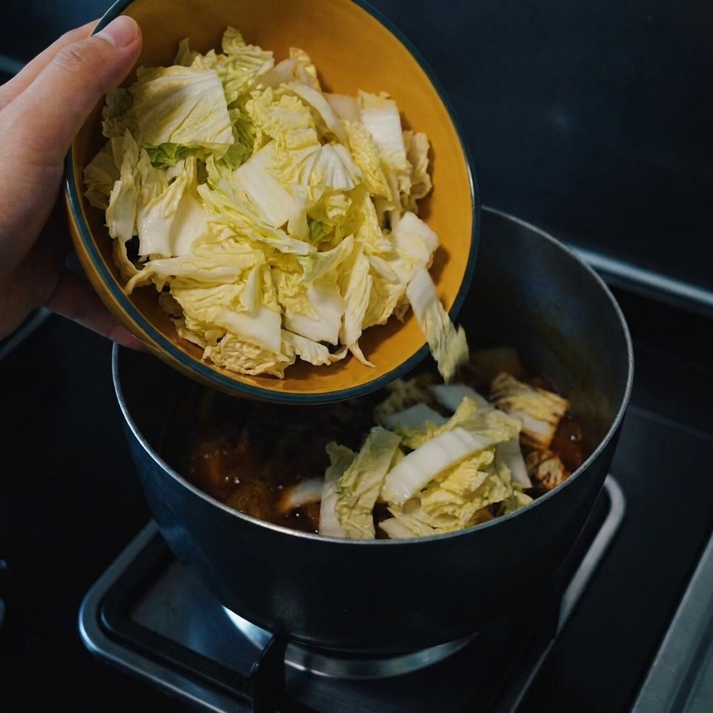 Freshly chopped cabbage being added to the simmering pot.