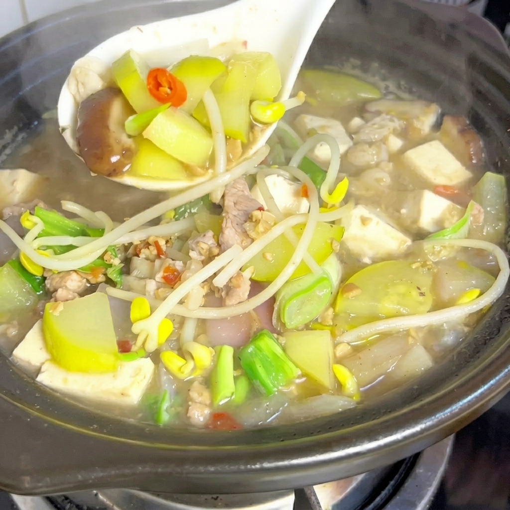 A green chili pepper halved and being sliced into small, seedless pieces.