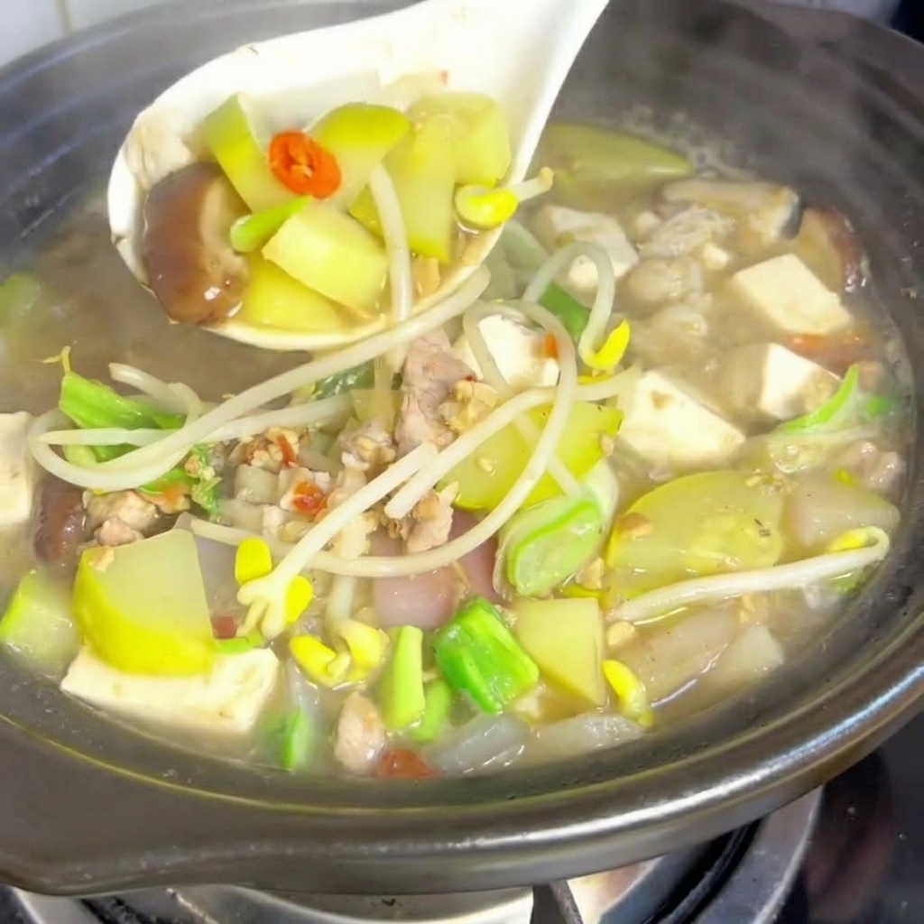 A block of soft white tofu being cut into neat, small cubes.