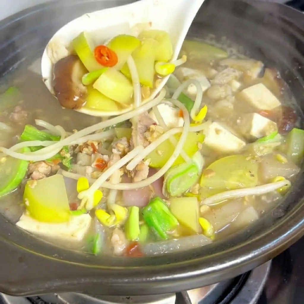 Slices of pork belly browning in a hot clay pot.
