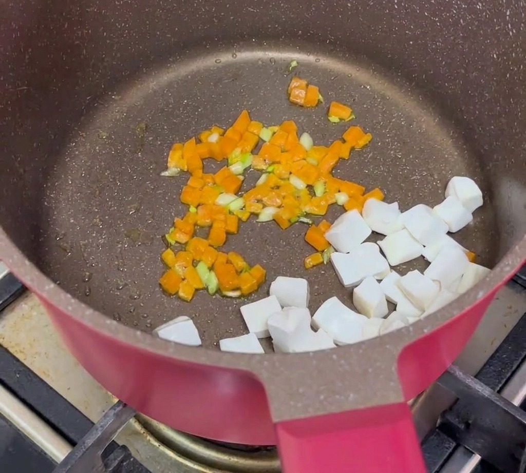 Tofu cubes, cooked minced beef, and sautéed carrots combined together in a pan.