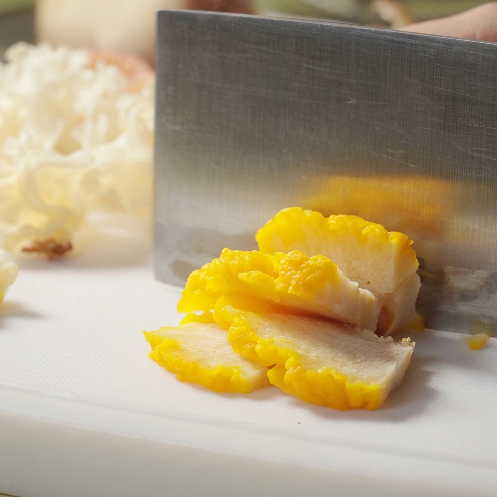 Hand tearing oyster mushroom caps into long, manageable strips.