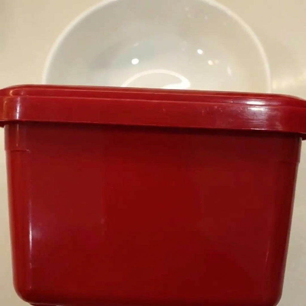 Spicy sauce base ingredients being mixed together in a white bowl.