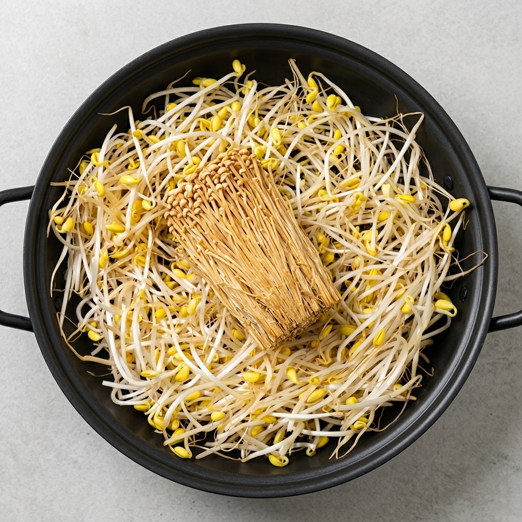 A wide variety of prepared ingredients including bean sprouts, tofu, enoki mushrooms, spam, and sausages arranged neatly in a pot.