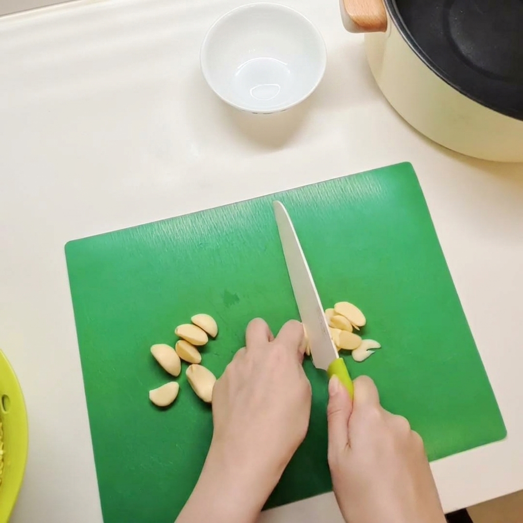 A small white bowl containing a mixture of red chili paste, soy sauce, and seasonings being stirred together.