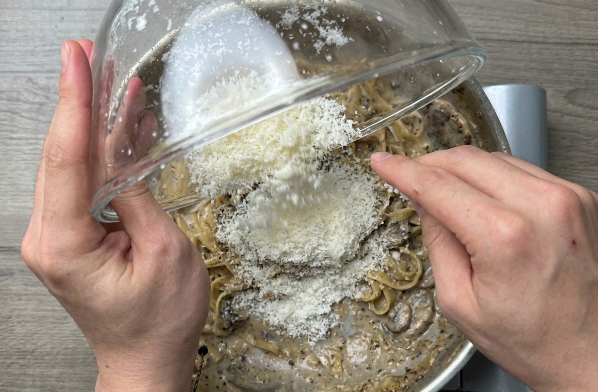 A close up shot of the finished spaghetti being tossed in the skillet to create a glossy sauce.