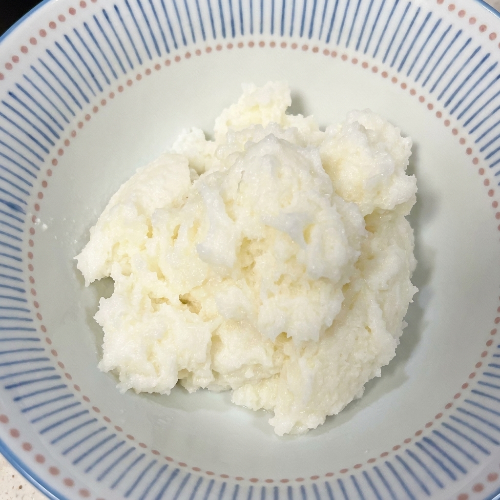 A close-up shot of a ceramic bowl with a blue patterned rim filled with freshly cooked white rice.