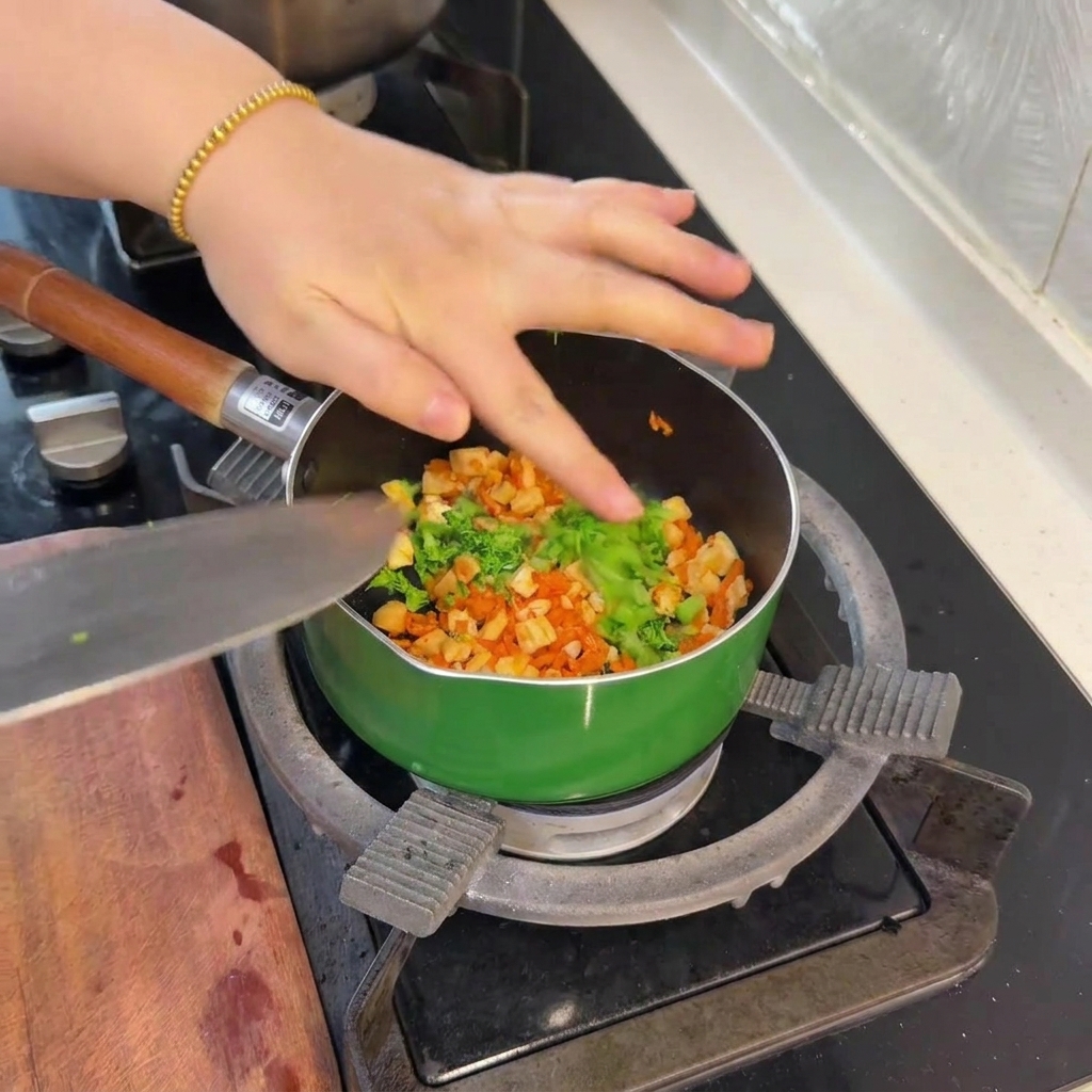Small pieces of bright green blanched broccoli being added to the pan of salmon and carrots.