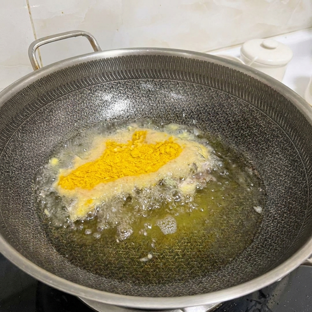 Marinated chicken steaks coated in breadcrumbs being shallow-fried in a hot wok with bubbling oil.