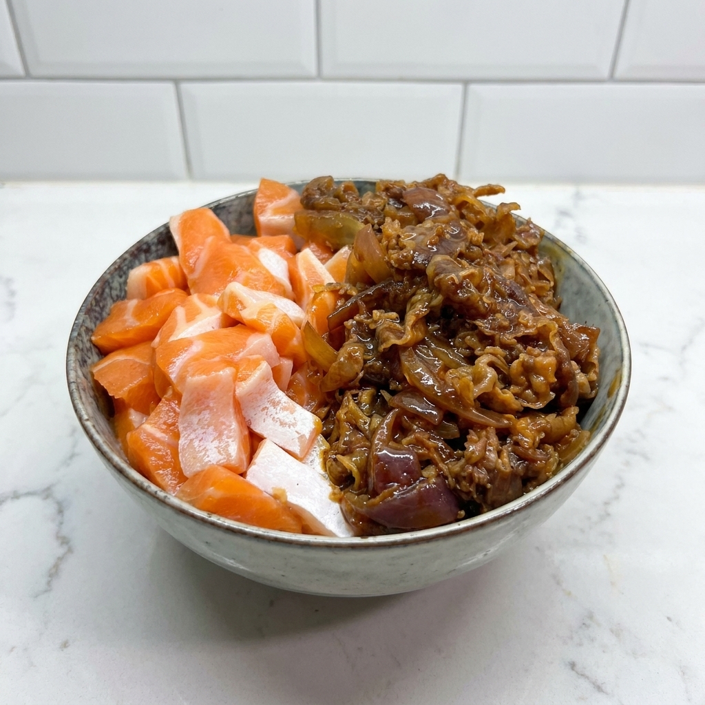 A ceramic bowl containing raw salmon slices on the left and dark, saucy stir-fried beef and onions on the right.