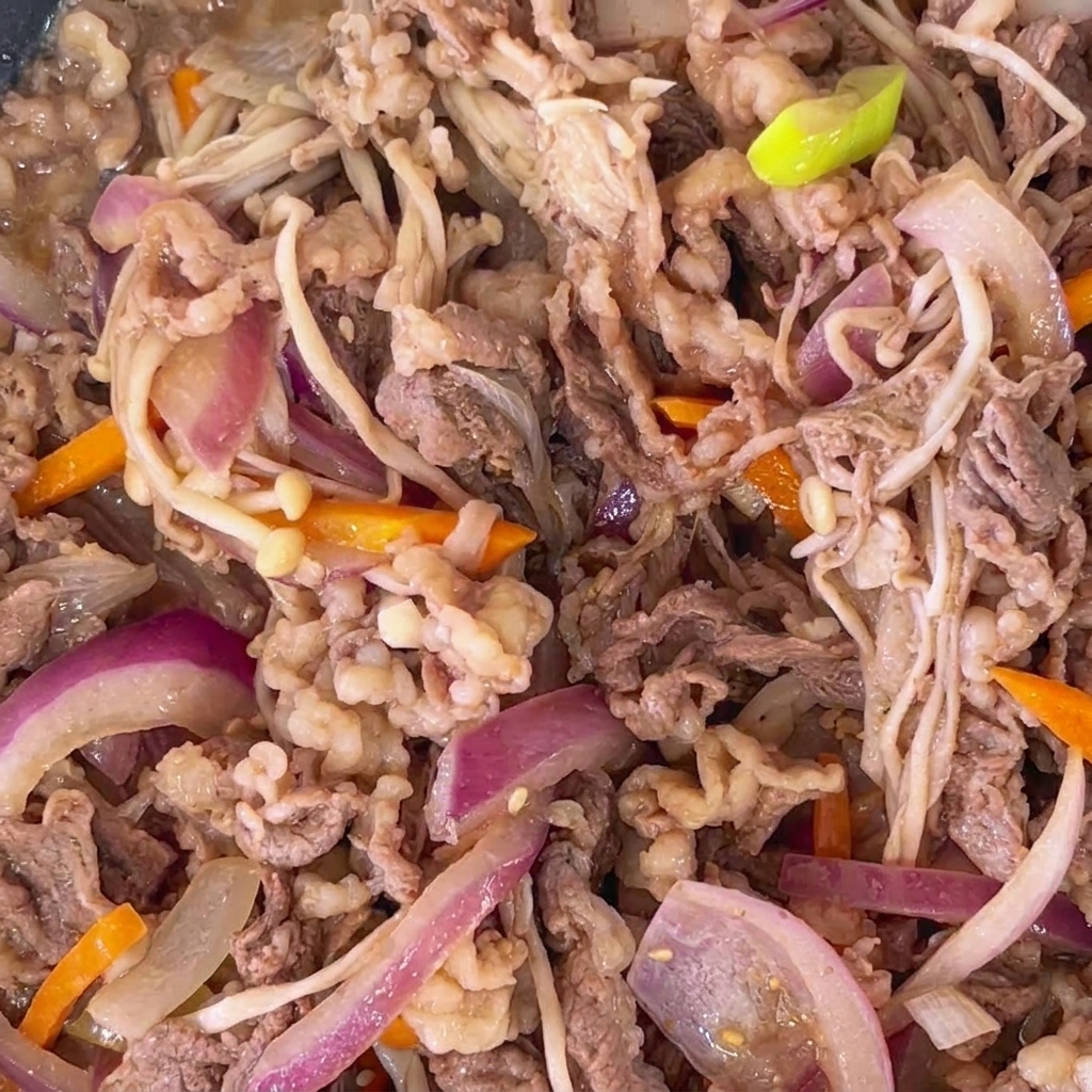 Close-up of fully cooked beef bulgogi with visible toasted sesame seeds scattered throughout.
