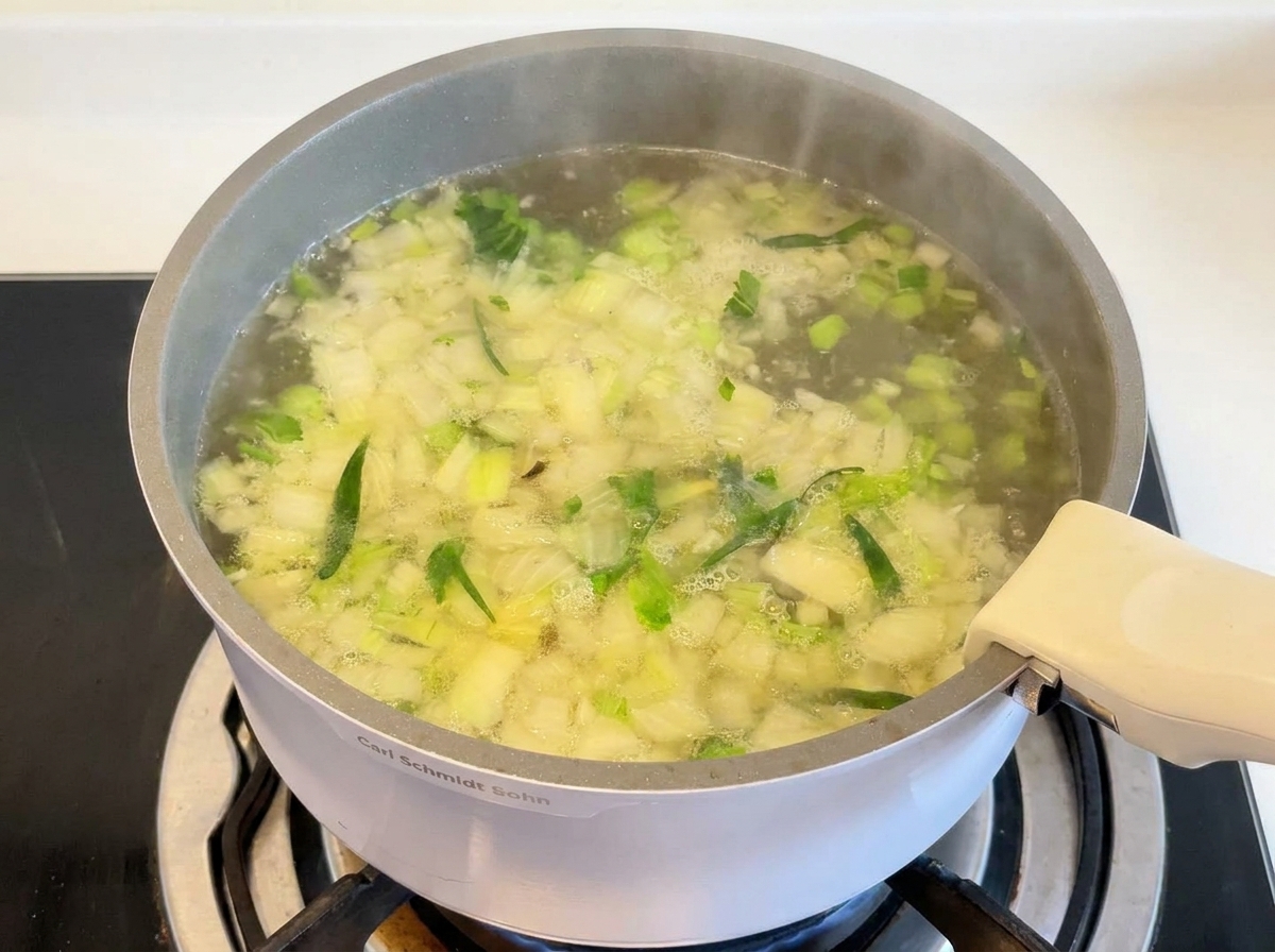 Chicken thighs and rice simmering in a bubbling broth.