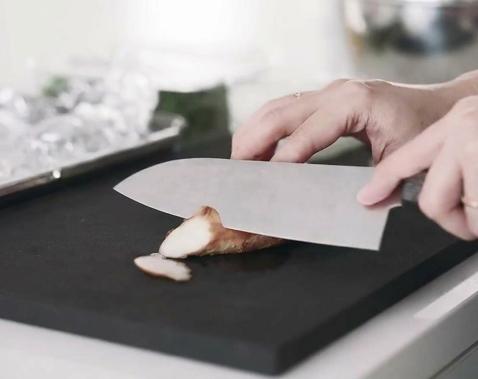 Slices of cooked chicken breast arranged on a cutting board.