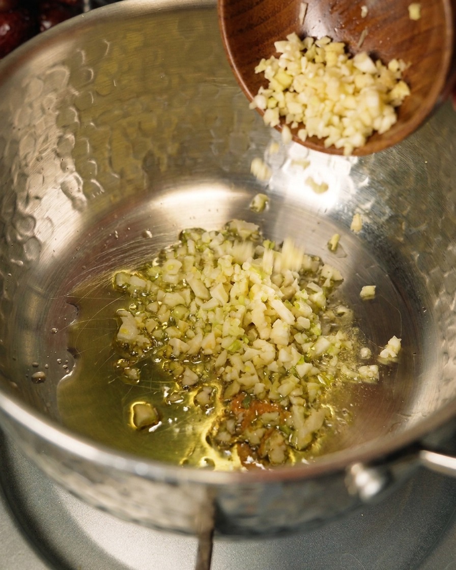 Onions and garlic sautéing in olive oil in a pot.