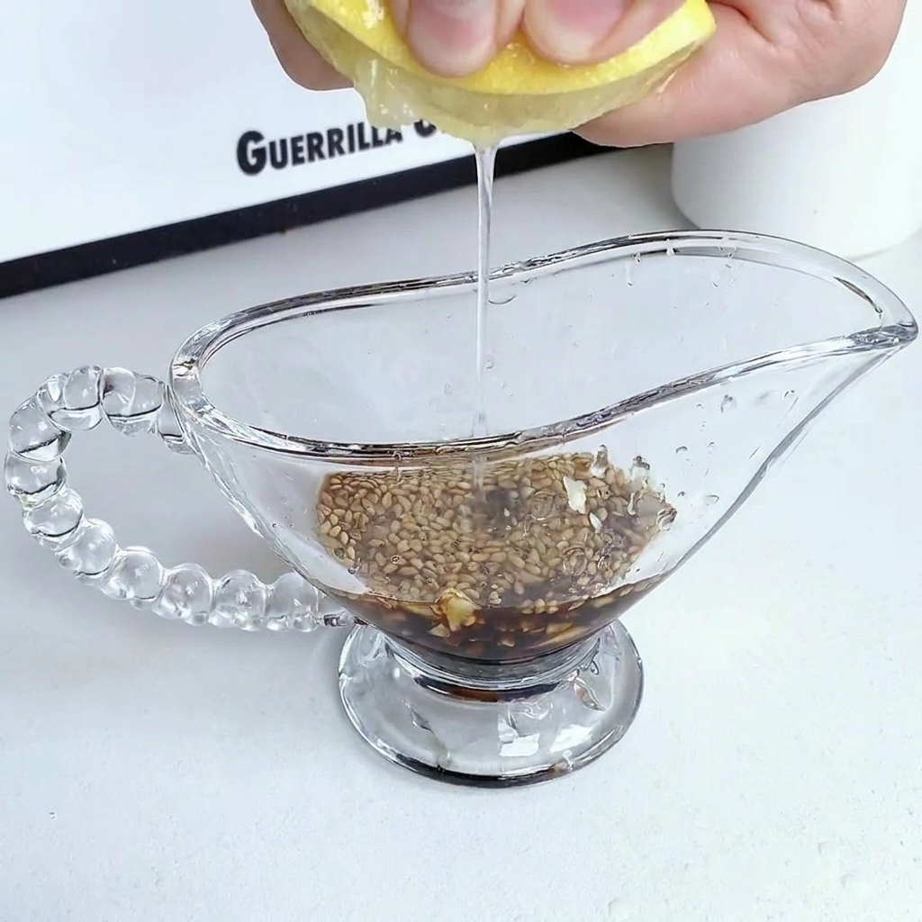 Sauce ingredients being mixed together in a clear glass pitcher.