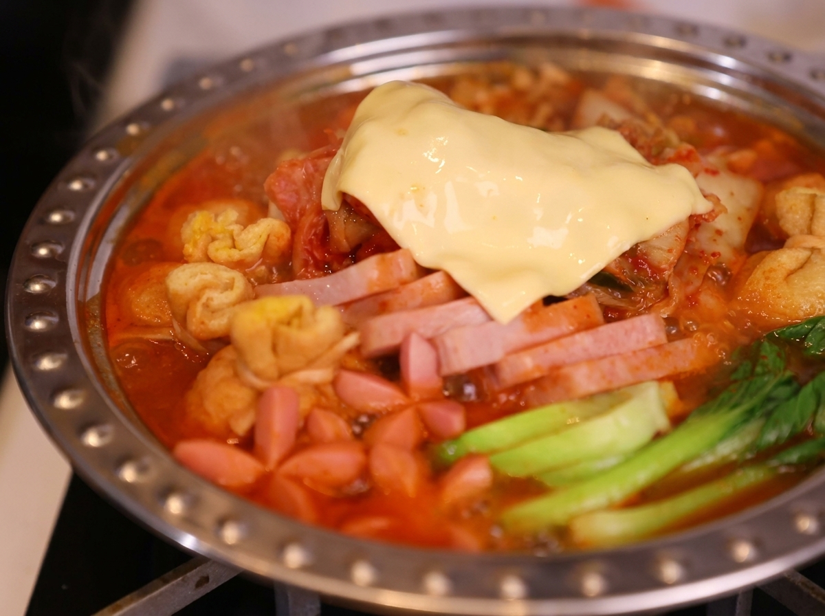 Clear water being poured into the pot filled with ingredients, preparing it for the lid to be placed on top.