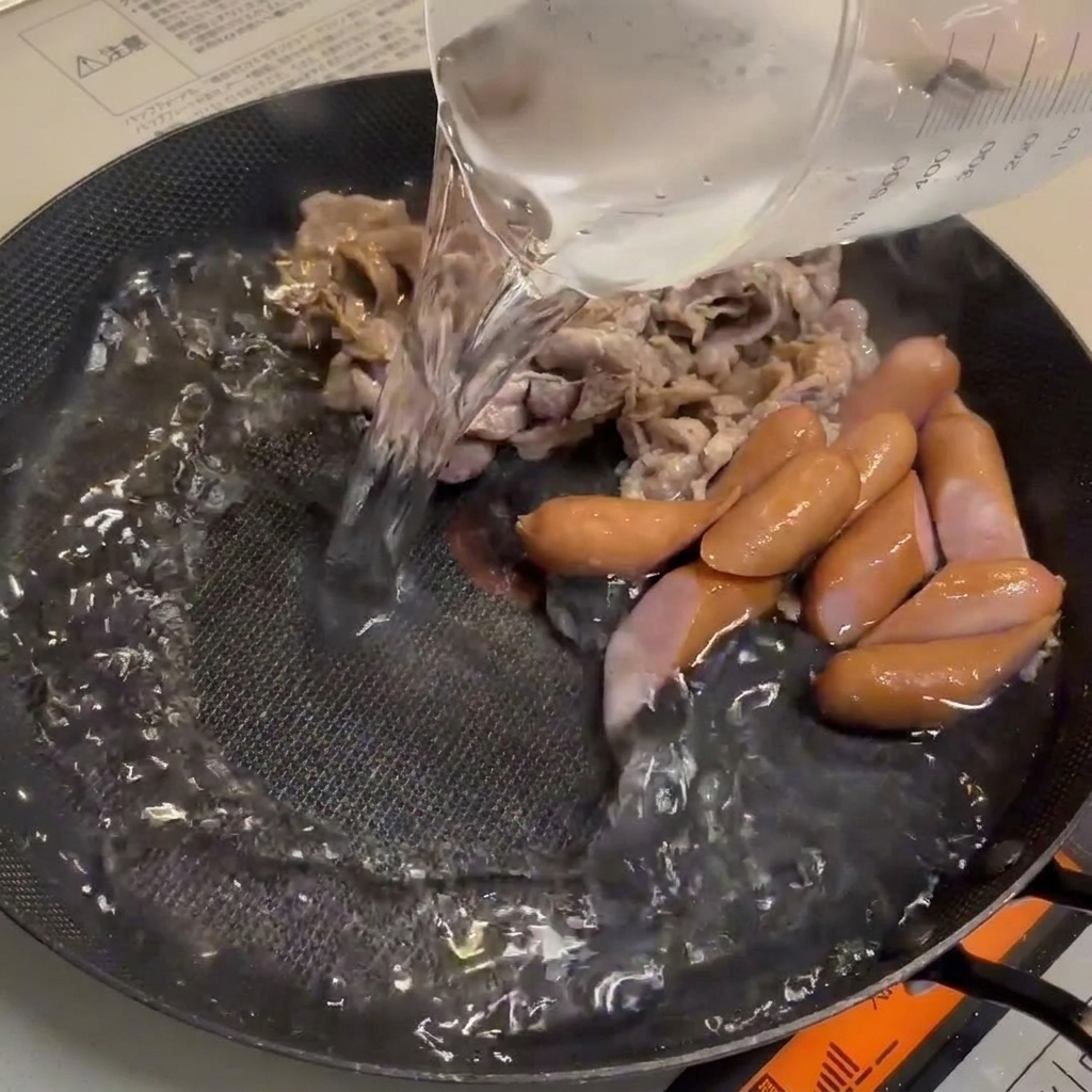 Water being added to the pan, creating a rich broth base.