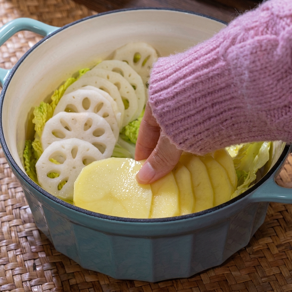 A colorful arrangement of sliced potatoes and various mushrooms inside the cooking pot.
