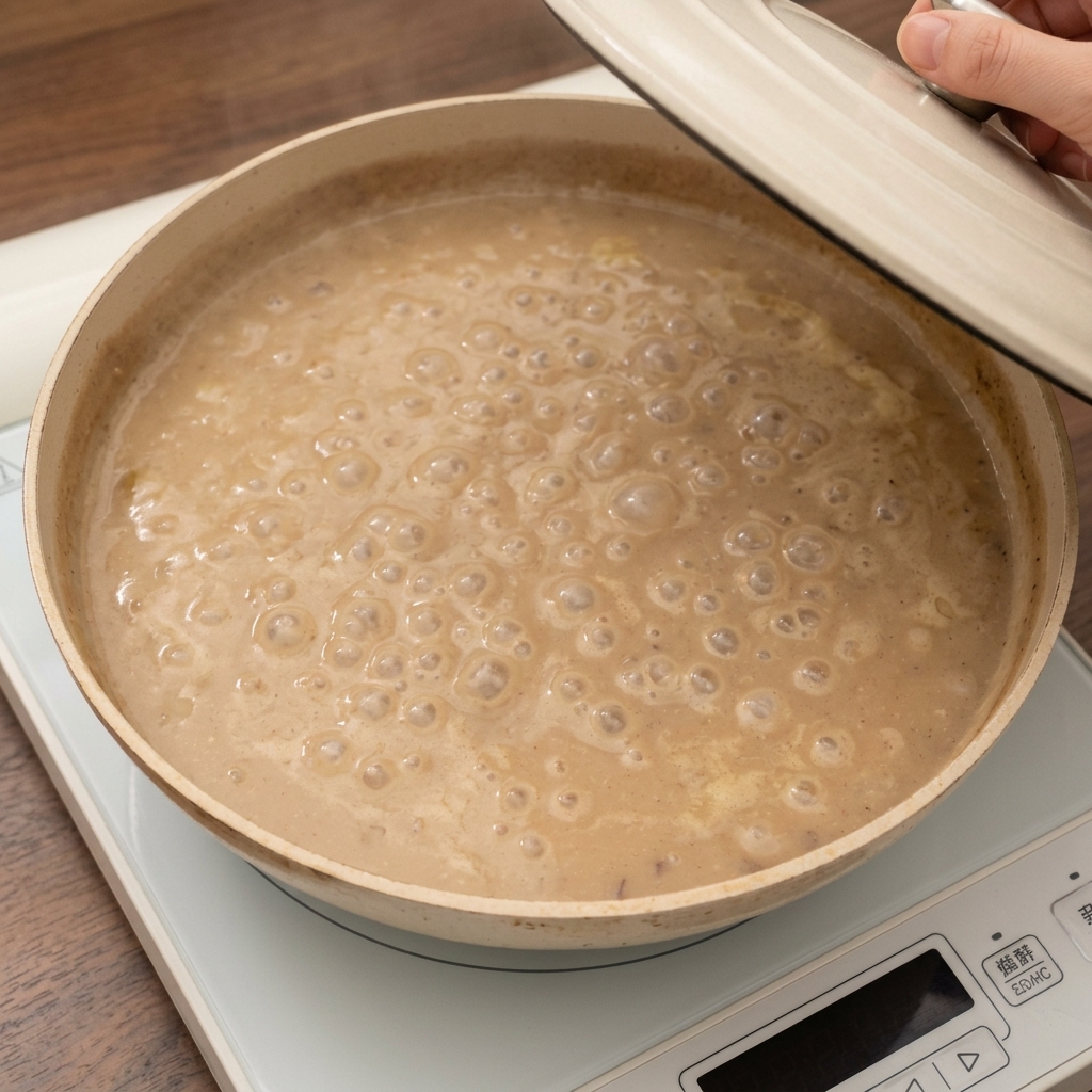 Clam meat being mixed into the creamy, potato-filled soup.