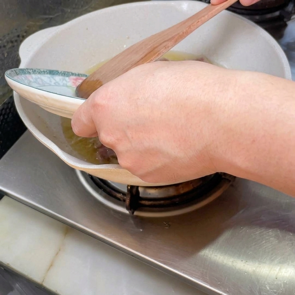 Minced beef and pork browning in a pan over medium-high heat.