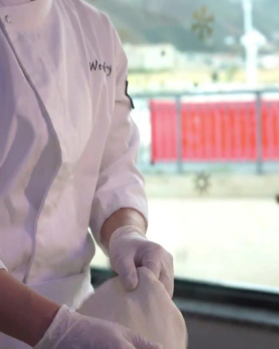 The pizza dough base being skillfully spun by hand to widen and thin out the center.