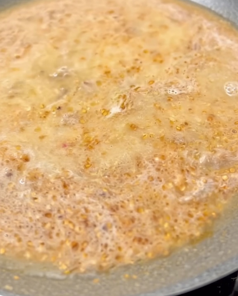 Milk being stirred into the simmering Tantanmen broth in the pan.