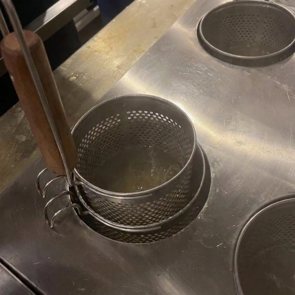Noodles being stirred in boiling water with wooden chopsticks.