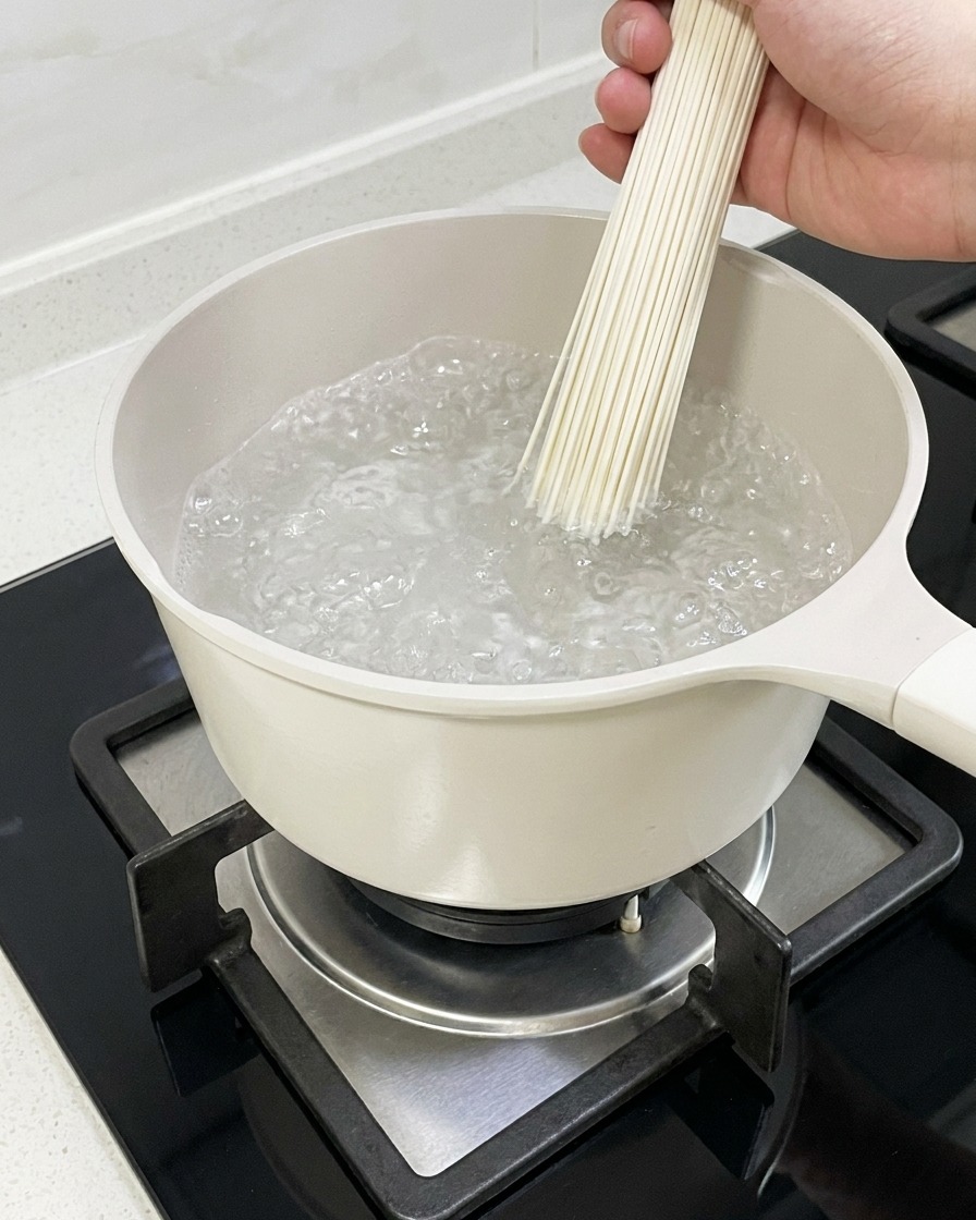 Ramen noodles boiling in a pot of water.