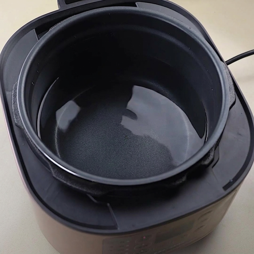 Chicken bones and parts submerged in a pot of water on the stove.
