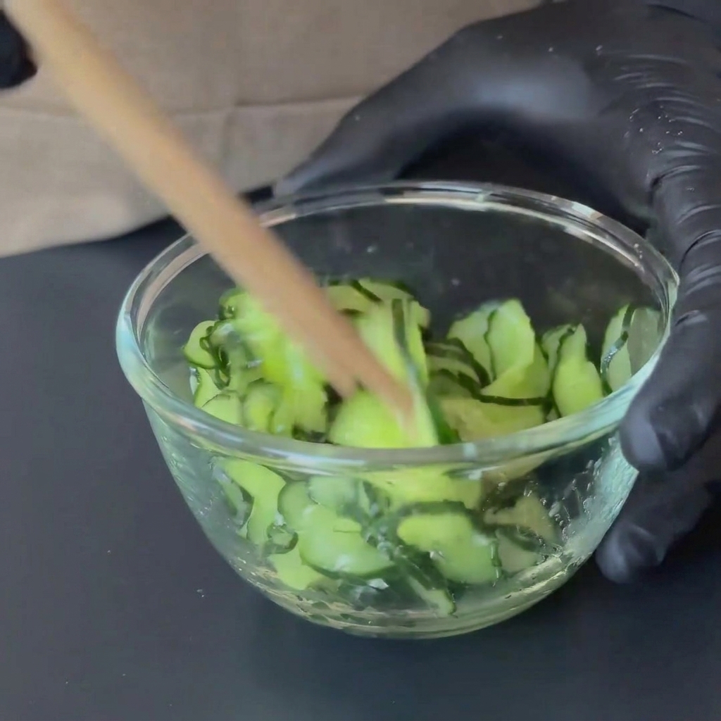 Sesame paste and vibrant red chili oil being mixed together in a bowl.