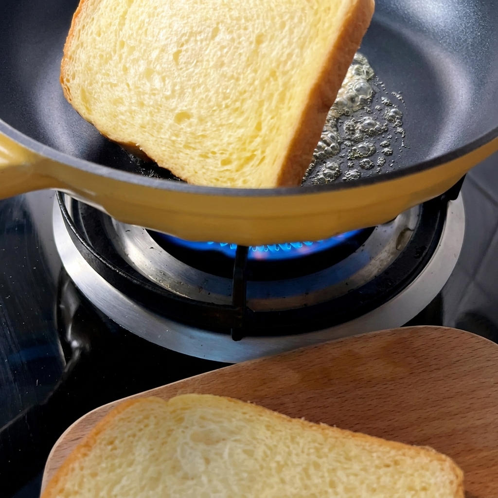 Golden brown toasted bread slices in a yellow pan with melted butter.