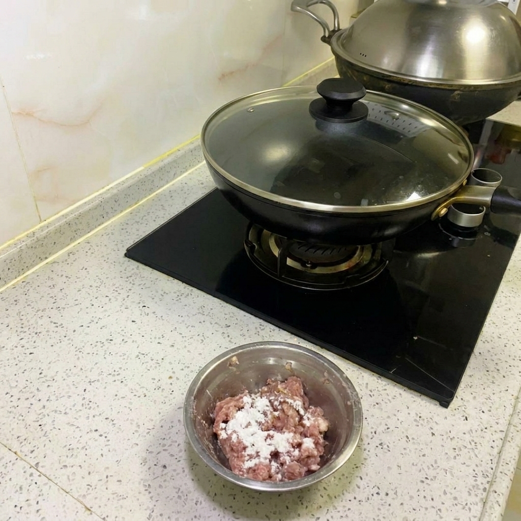 Minced meat being vigorously stirred with metal chopsticks until sticky.